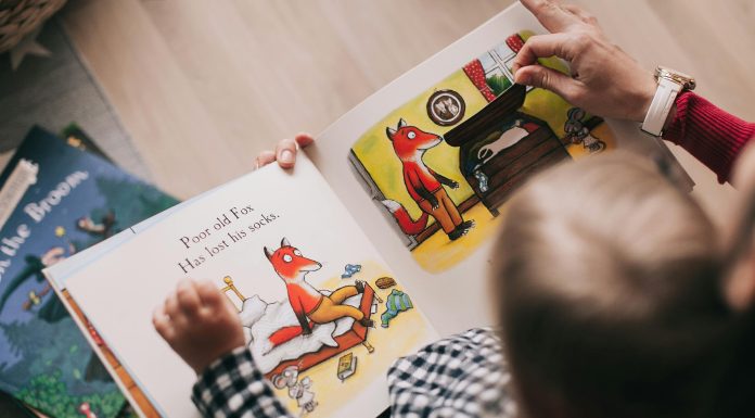 Back-to-School Books: Fresh Picks to Get Kids Excited for the Classroom Young child sitting on steps reading one of their back-to-school books.