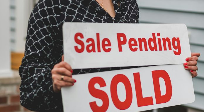 For sale sign in front of a suburban home, symbolizing opportunities in the August housing market