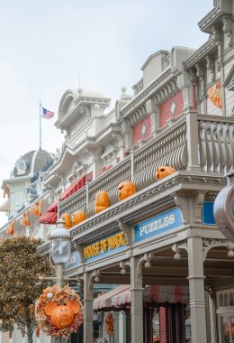 Miguel Joya via Unsplash buildings on Main Street USA at Magic Kindgom with pumpkins on top and a Mickey pumpkin wreath on a light post